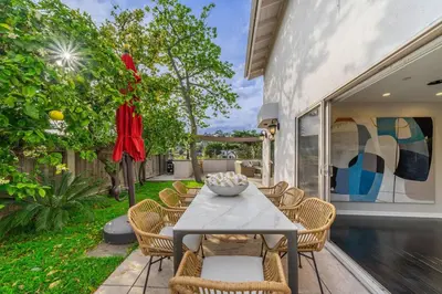 a patio with a table and chairs and a garden at Spacious Hollywood Private Villa with 7 Bedrooms and Pool in Los Angeles