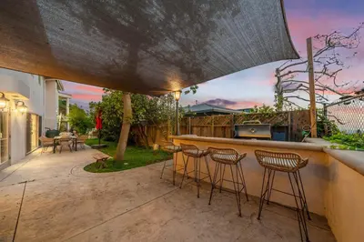 a patio with a bar with stools in a backyard at Spacious Hollywood Private Villa with 7 Bedrooms and Pool in Los Angeles