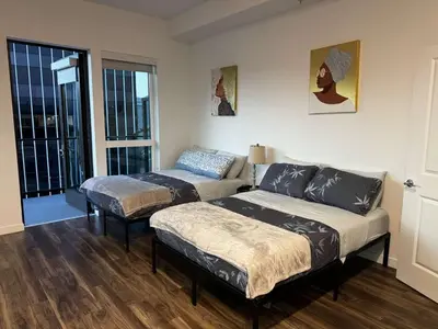 a bedroom with two beds and a couch and a window at Vine & Sunset Loft Free Parking and WIFI in Los Angeles