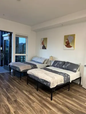 a bedroom with two beds and a large window at Vine & Sunset Loft Free Parking and WIFI in Los Angeles