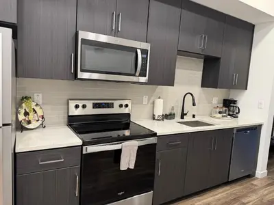 a kitchen with black cabinets and a microwave at Vine & Sunset Loft Free Parking and WIFI in Los Angeles