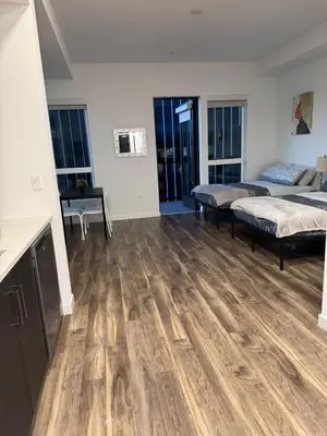 a large room with wooden floors and two beds at Vine & Sunset Loft Free Parking and WIFI in Los Angeles