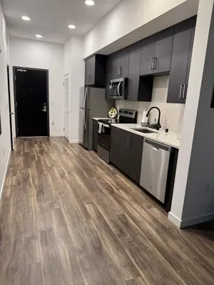 a kitchen with black cabinets and a wooden floor at Vine & Sunset Loft Free Parking and WIFI in Los Angeles