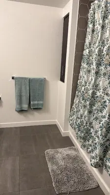a bathroom with green towels and a rug at Vine & Sunset Loft Free Parking and WIFI in Los Angeles