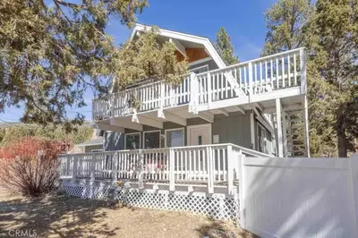 a large white house with a white fence at Navigate Stays Best Location Pet Friendly Games in Big Bear City