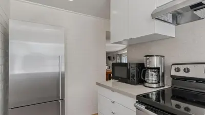 a kitchen with a stainless steel refrigerator and white cabinets at Malibu Hills Studio w Mountain Views Near beaches Cielo Nook by AvantStay in Malibu Beach
