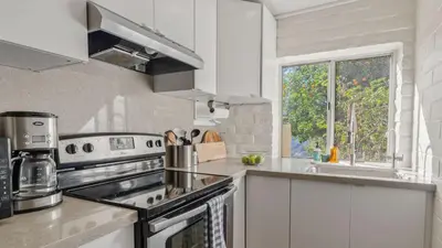 a white kitchen with a stove and a window at Malibu Hills Studio w Mountain Views Near beaches Cielo Nook by AvantStay in Malibu Beach