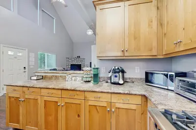 a kitchen with wooden cabinets and a counter top at 7 Mi to Snow Valley Mountain Resort Quiet Cabin in Running Springs