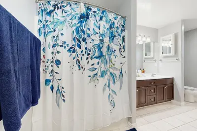 a bathroom with a shower with a blue and white shower curtain at 7 Mi to Snow Valley Mountain Resort Quiet Cabin in Running Springs