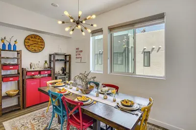 a dining room with a table with chairs and a clock at 2 Mi to Cabrillo Beach Luxe LA Gem with Balcony in San Pedro