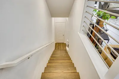a staircase with white walls and wooden floors at 2 Mi to Cabrillo Beach Luxe LA Gem with Balcony in San Pedro
