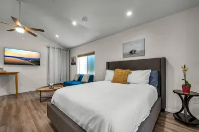 a bedroom with a large bed and a blue chair at Coldwater Canyon ADU in Los Angeles