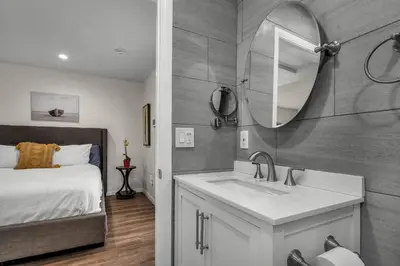 a bathroom with a sink and a mirror and a bed at Coldwater Canyon ADU in Los Angeles
