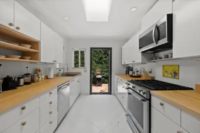 a kitchen with white cabinets and a stove top oven at New Listing Midcity West Villa by Colby & Conrad in Los Angeles