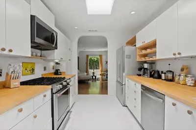 a kitchen with white cabinets and a stove at New Listing Midcity West Villa by Colby & Conrad in Los Angeles