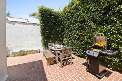 a patio with a barbecue and a table and a grill at New Listing Midcity West Villa by Colby & Conrad in Los Angeles