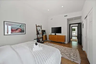 a white bedroom with a bed and a tv at New Listing Midcity West Villa by Colby & Conrad in Los Angeles