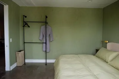 a bedroom with a bed and a purple shirt hanging on a wall at Cozy Charm in West Hollywood in Los Angeles