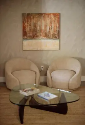 a living room with two chairs and a glass table at Cozy Charm in West Hollywood in Los Angeles