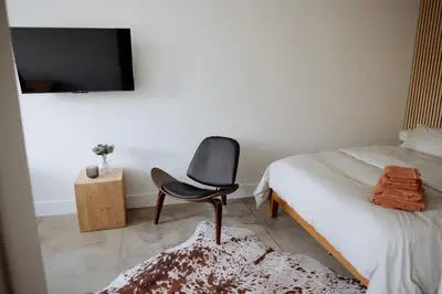a chair sitting on a bed in a bedroom at Cozy Charm in West Hollywood in Los Angeles