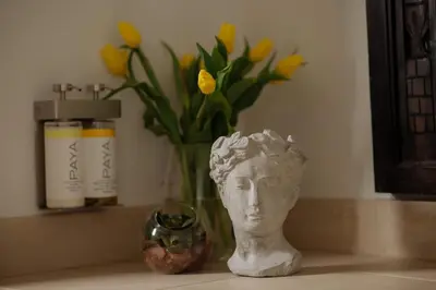 a vase with a head on a counter with yellow flowers at Dreamy Mid-Century Modern Pad in Los Angeles