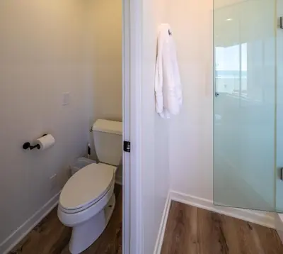 a bathroom with a toilet and a glass shower at Time2Relax in Oxnard