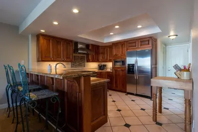 a kitchen with wooden cabinets and a stainless steel refrigerator at Harbor View in Oxnard