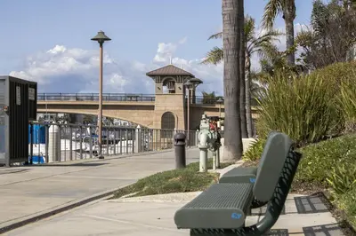 a park bench next to a fire hydrant on a sidewalk at Harbor View in Oxnard