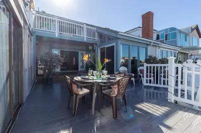 a patio with a table and chairs on a deck at Harbor View in Oxnard
