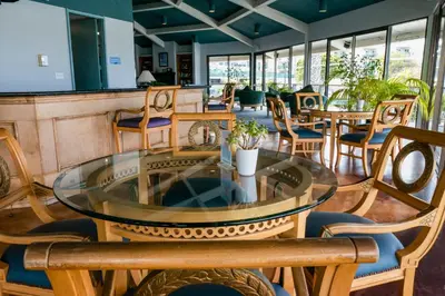 a restaurant with a glass table and chairs at Waterfront 104 in Oxnard