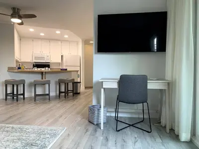 a living room with a table and chairs and a television at Waterfront 104 in Oxnard