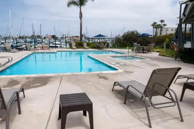 a large swimming pool with chairs and a table and a tablektop at Waterfront 104 in Oxnard