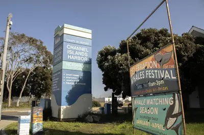 a sign in front of a building with two signs at Waterfront 104 in Oxnard