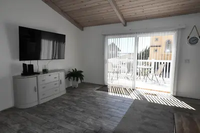 a living room with a flat screen tv and a large window at Ocean Blue in Oxnard