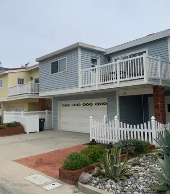 a large house with a white fence in front of it at Ocean Blue in Oxnard