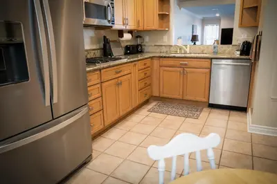 a kitchen with wooden cabinets and a stainless steel refrigerator at Surfside Four in Port Hueneme