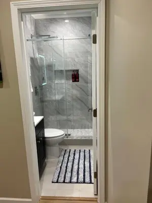 a bathroom with a shower with a toilet and a rug at House in Torrance