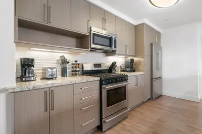 a kitchen with stainless steel appliances and wooden cabinets at The Amber Serene Peaceful Retreat Pool Gym And Jacuzzi in Los Angeles