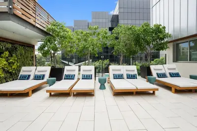 a group of lounge chairs sitting on a patio at The Amber Serene Peaceful Retreat Pool Gym And Jacuzzi in Los Angeles