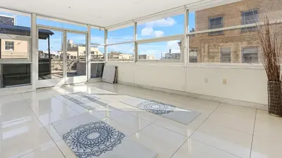 a large room with white tile floors and windows at Skyline Lofts by AvantStay: a multi-level industrial-chic retreat in DTLA with rooftop views soaring ceilings steps to dining music culture in Los Angeles