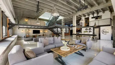 a large living room with couches and a table at Skyline Lofts by AvantStay: a multi-level industrial-chic retreat in DTLA with rooftop views soaring ceilings steps to dining music culture in Los Angeles