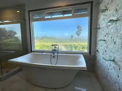 a large bath tub in a bathroom with a window at Spectacular City Mountain Views Remodeled Open Plan 3 bdr Home Pool Jacuzzi Oasis in Engine Company Number 109 Heliport