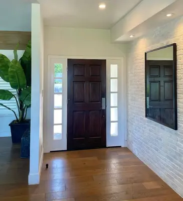 a hallway with a wooden door and a brick wall at Spectacular City Mountain Views Remodeled Open Plan 3 bdr Home Pool Jacuzzi Oasis in Engine Company Number 109 Heliport