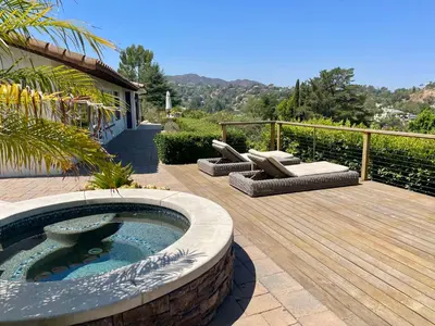 a patio with a hot tub and a wooden deck at Spectacular City Mountain Views Remodeled Open Plan 3 bdr Home Pool Jacuzzi Oasis in Engine Company Number 109 Heliport
