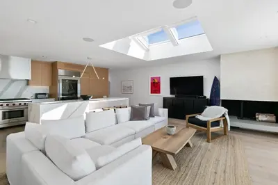 a living room with a white couch and a kitchen at Playa Del Sol by Stay Awhile Villas in Malibu Beach
