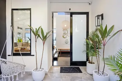 a hallway with three potted plants in front of a door at Six Senses by Stay Awhile Villas in Los Angeles