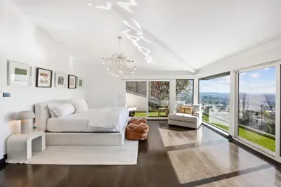 a white bedroom with a bed and a chandelier at Six Senses by Stay Awhile Villas in Los Angeles