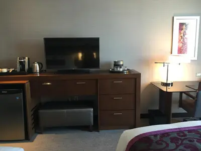a hotel room with a desk with a flat screen tv at Parkwest Bicycle Casino in Bell Gardens