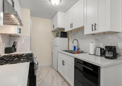 a kitchen with white cabinets and a white refrigerator at Cozy&Stylish DT Alhambra Living walk to Starbucks in Alhambra