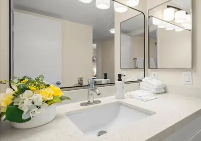 a bathroom with a sink with a vase of flowers at Cozy&Stylish DT Alhambra Living walk to Starbucks in Alhambra